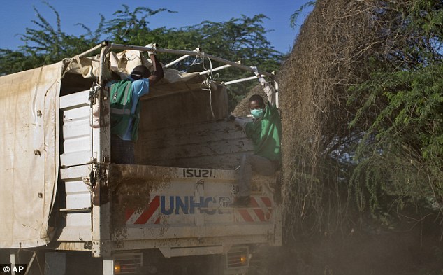 Workers ride in a truck carrying the dead bodies from the scene of the attack at Garissa University College